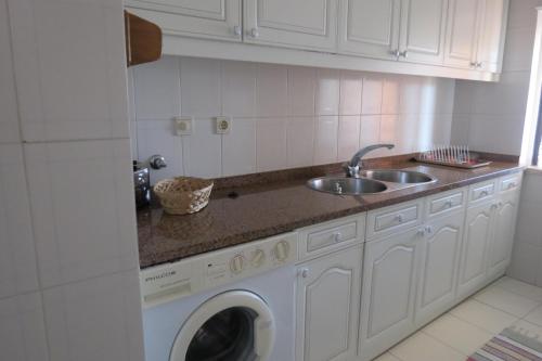 una cocina con lavadora y fregadero en Olá Ericeira Apartment, en Ericeira