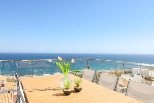 a table with plants on top of a balcony with the ocean at Stay In Carabassi II in Gran Alacant