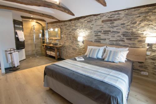 una camera da letto con un letto grande e un muro di pietra di Gites des Esperelles a Saint-Privat-de-Vallongue