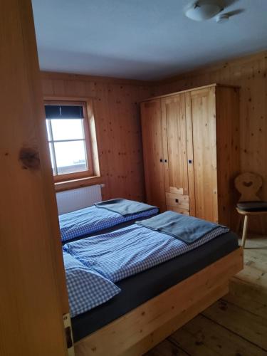 two beds in a small room with a window at Fasserhof in Bramberg am Wildkogel
