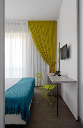a bedroom with a bed and a desk with a laptop at Hotel Madison in Rimini