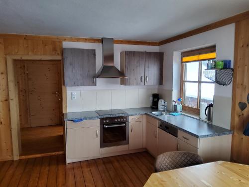 a kitchen with white cabinets and a stove top oven at Fasserhof in Bramberg am Wildkogel