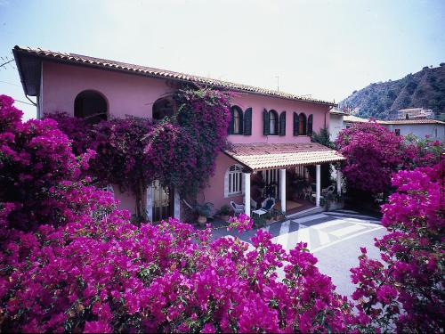 una casa con flores púrpuras delante de ella en Hotel Lido Mediterranee, en Taormina