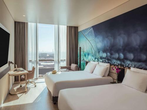 a hotel room with two beds and a large window at Novotel Mexico City Toreo in Mexico City