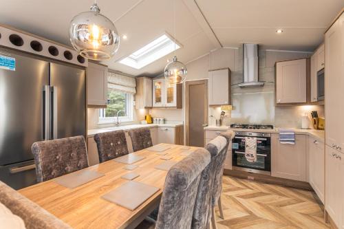 a kitchen with a wooden table with chairs around it at Lakeside Retreat Lodge With Hot Tub in Pocklington