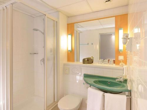 a bathroom with a green sink and a shower at Ibis Wien Mariahilf in Vienna