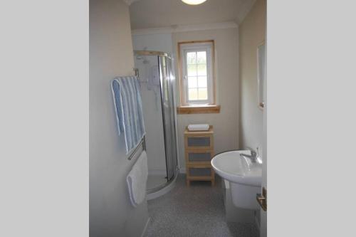 a bathroom with a sink and a shower and a toilet at Mingulay, Cuil Bay in Appin