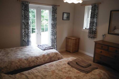 a bedroom with two beds and a window at Mingulay, Cuil Bay in Appin