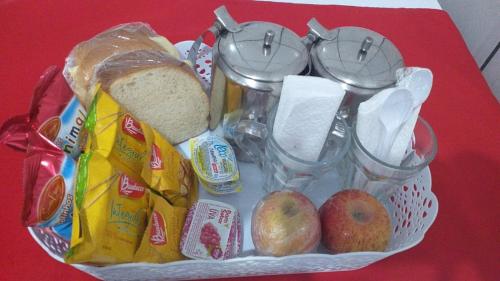 a basket of food with bread and apples on a table at Hotel Tiquatira - Zona Leste in Sao Paulo
