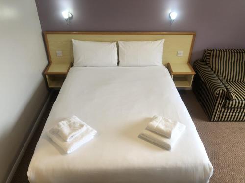 a large white bed with two pillows on it at Redwings Lodge Rutland in Uppingham