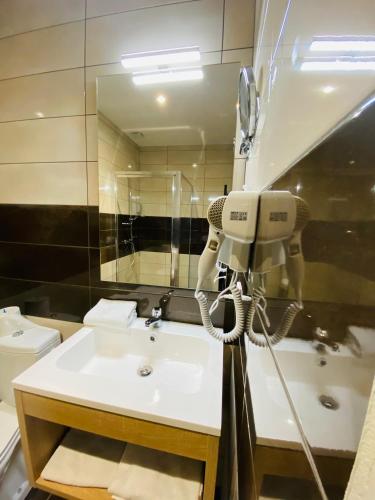 a bathroom with a phone and a sink at Hotel Martinez Grenay in Grenay