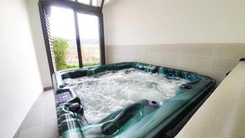 a bathroom with a tub with water in it at 100% Relax avec Jacuzzi Privatif in Sarlat-la-Canéda