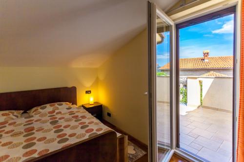 une chambre avec un lit et une porte coulissante en verre dans l'établissement Apartments Dario, à Porat