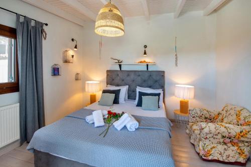 a bedroom with a bed with a couch and a chair at Hara Luxury House in Gaios