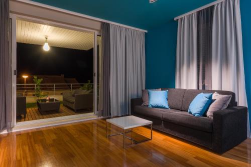 a living room with blue walls and a couch at Apartments Villa Azzurra Bol in Bol