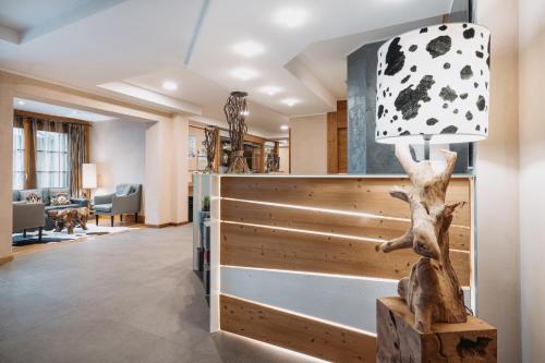 a living room with a lamp and a room with a couch at Hotel Chalet Del Brenta in Madonna di Campiglio