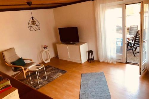 a living room with a tv and a table and chairs at Haus im Garten „zentral und doch sehr ruhig“ in Elten