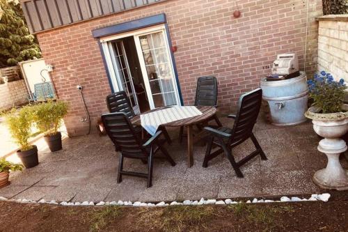 a patio with a wooden table and chairs at Haus im Garten „zentral und doch sehr ruhig“ in Elten