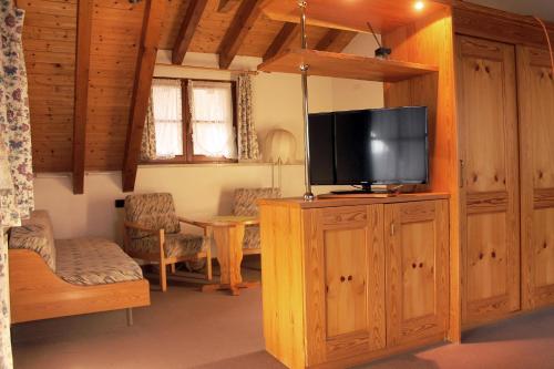 a living room with a television on a wooden cabinet at Erlebnisgastronomie Lochmuhle in Eigeltingen
