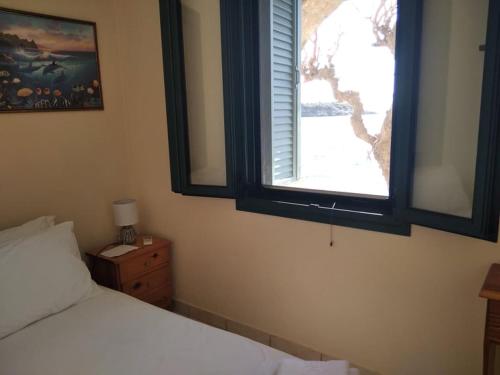 a bedroom with a white bed and a window at Gorgones, sea-front, great view in Kardamili