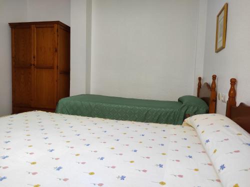 a bedroom with two twin beds and a cabinet at Hostal Centro Ejido in El Ejido
