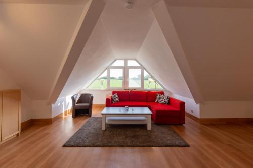 sala de estar con sofá rojo y mesa en Ferienwohnung Mohnblume - Strandhaus Lobbe, en Middelhagen