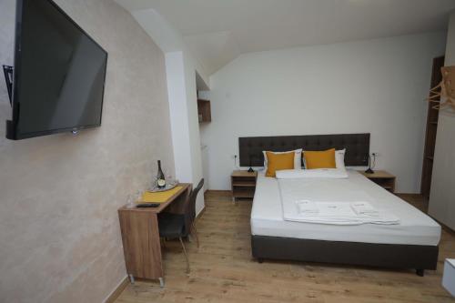 une chambre avec un lit et une télévision à écran plat dans l'établissement PALACE MEGDAN, à Užice