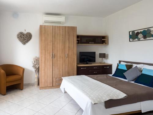 a bedroom with a large bed and a television at Apartments Summer Bloom in Krk