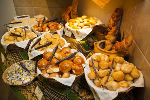 a table with many baskets of bread and pastries at Xima Exclusive Cusco in Cusco