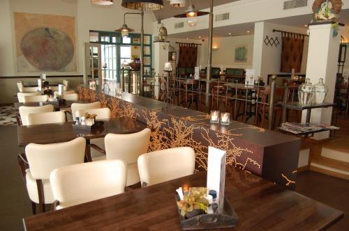 a restaurant with tables and chairs and a bar at Best Western Hotel Nobis Eindhoven-Venlo A67 in Asten