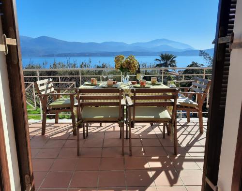 a table and chairs on a patio with a view of the ocean at Alekos Beach Houses-Alekos Beach Complex in Lixouri