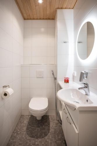a white bathroom with a toilet and a sink at Santa Claus Holiday Village in Rovaniemi