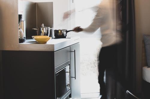 a man standing in a kitchen with a stove at Das Schlafwerk Stuttgart-Nord VOLLDIGITALES HOTEL-SELF-CHECK IN - keine Rezeption-LowBudget-cashless in Korntal-Münchingen