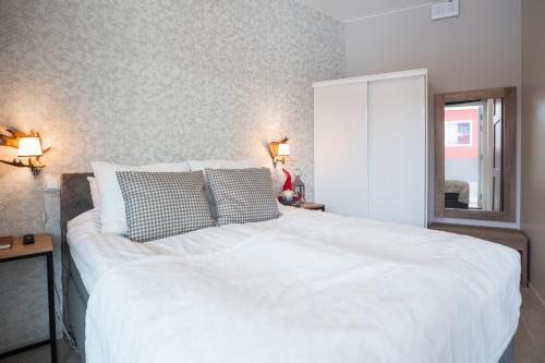 a large white bed in a bedroom with two lamps at Santa Claus Holiday Village in Rovaniemi