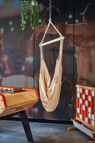 a hammock hanging from a wall next to a table at ibis Clamart Paris Velizy in Clamart