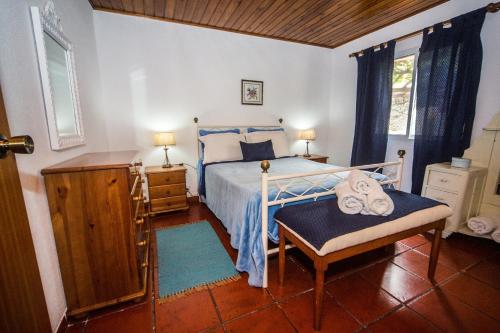 a bedroom with a bed and a chair in it at Mosteiros Sea House in Mosteiros
