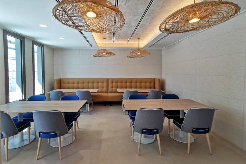 a waiting room with two tables and blue chairs at Hotel & Spa Castillo de Peñíscola 4* Sup in Peñíscola