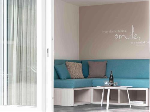 a blue couch in a living room with a table at Villaggio Camping Adria in Casal Borsetti