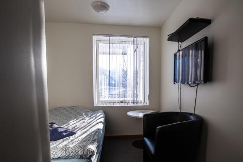 a small room with a bed and a window at TorskenSenteret in Torsken