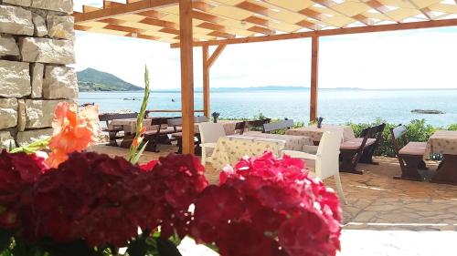 a patio with tables and chairs and flowers at Lavanda Mobile Homes & Villas in Orebić