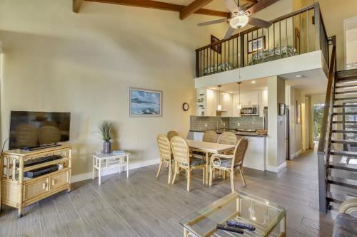 a dining room and living room with a table and a tv at Alea Condo in Kahuku