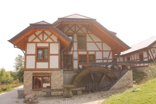 a large house with a large waterwheel in front of it at Erlebnisgastronomie Lochmuhle in Eigeltingen