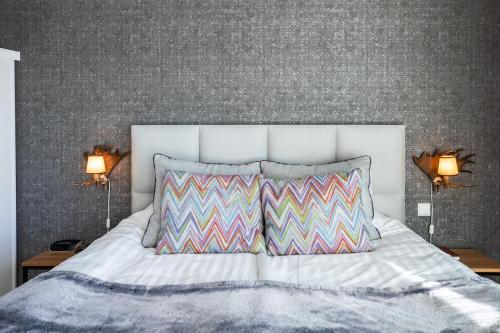 a bedroom with a white bed with two pillows at Santa Claus Holiday Village in Rovaniemi
