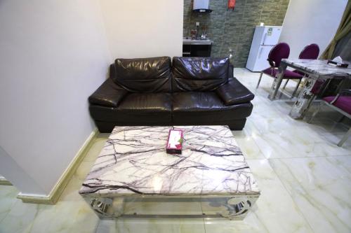 a leather couch in a living room with a table at Developed view Hotel in Jeddah