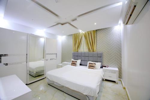 a bedroom with a white bed and a mirror at Developed view Hotel in Jeddah