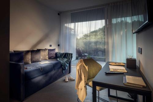 a living room with a couch and a table and a window at J44 Lifestyle Hotel in Lido di Jesolo