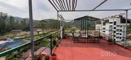 einen Balkon mit Blick auf ein Gebäude in der Unterkunft Greenview holiday inn in Munnar