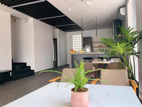 a dining room with a table and chairs and plants at Lá Homestay in Mỹ Phước