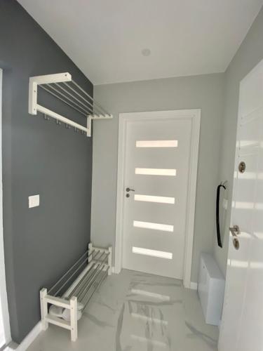 a bathroom with a white door and a toilet at TheHouse - Apartment Kamenitza in Velingrad