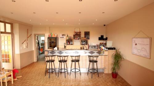 - un bar avec tabourets de bar dans la chambre dans l'établissement Entre Lacs et Volcans, à Aydat